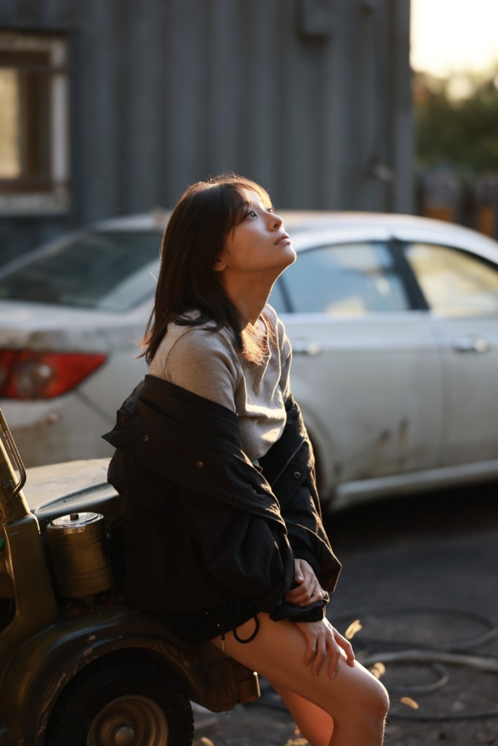 용마랜드, 차 옆에 앉아 햇빛을 바라보는 모델